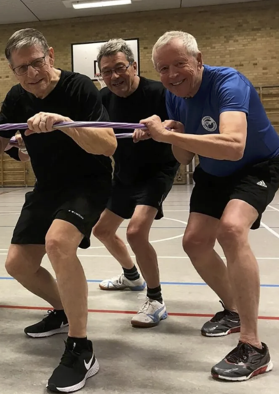 Mænd der dyrker herregymnastik sammen i gymnastiksal